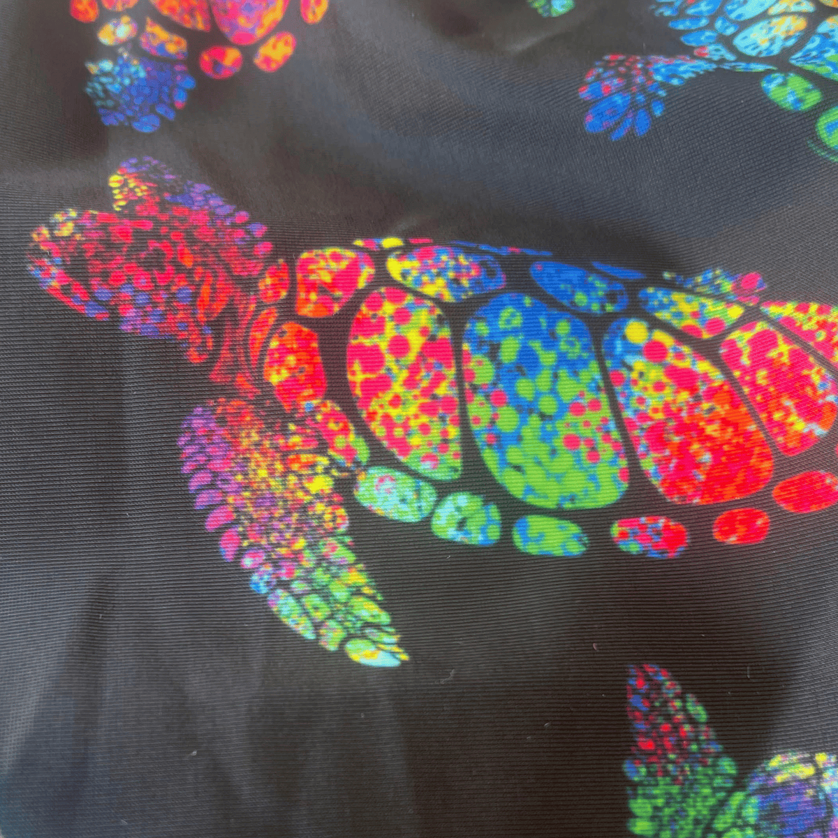 Kikx Extra Life Thin Strap Swimsuit in Larger Turtle Tango Print on Black Background with Neon Yellow Straps